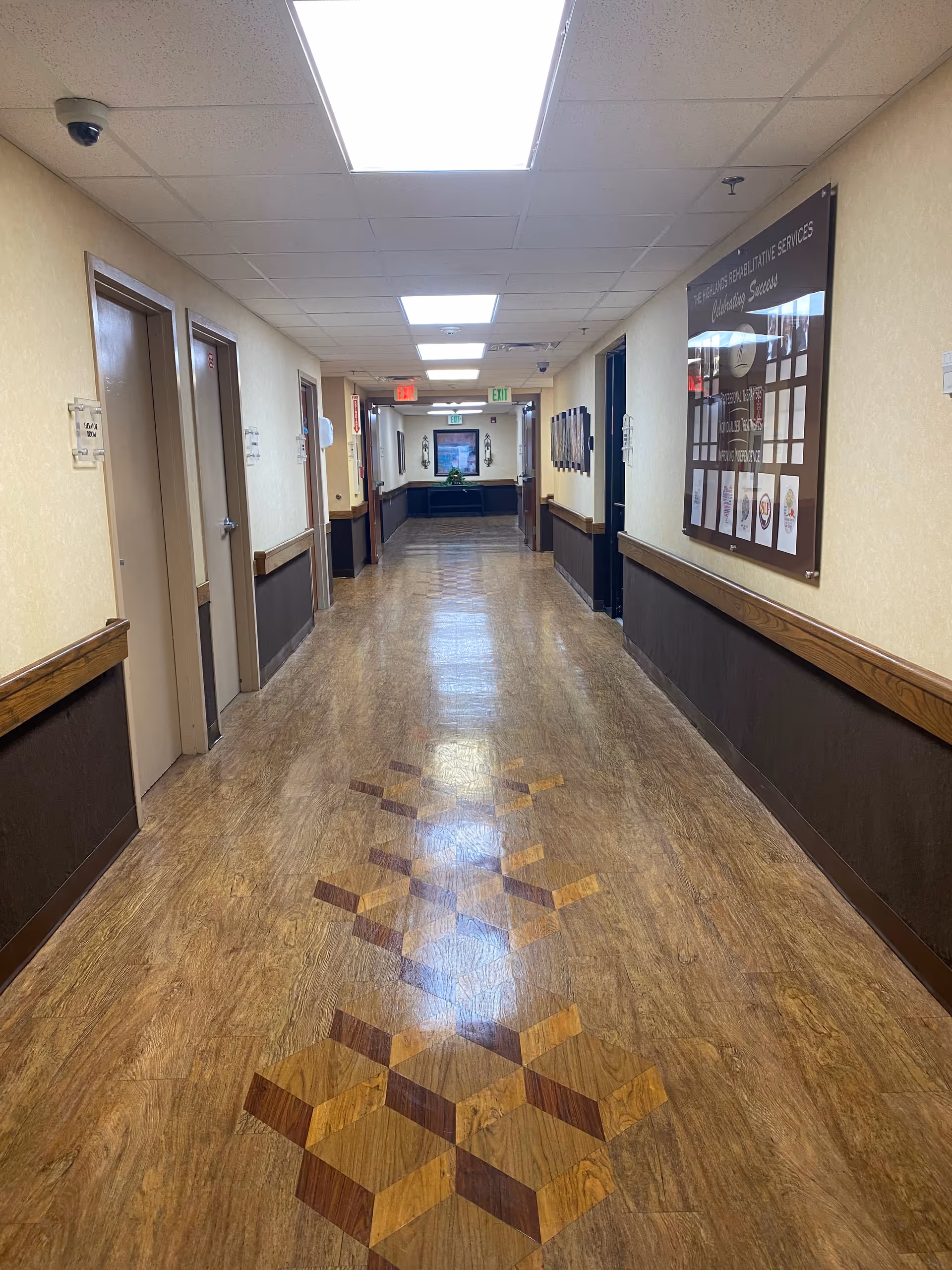 Long, well-lit hallway in a senior living facility with doors along both sides.