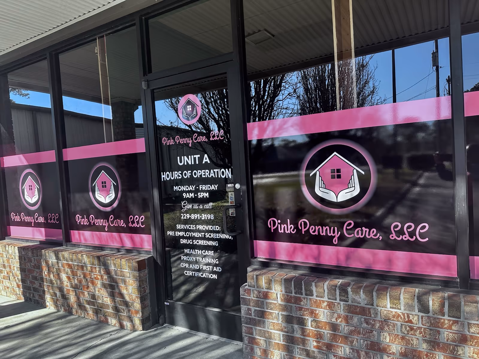 Exterior storefront with Pink Penny Care branding on windows and door.