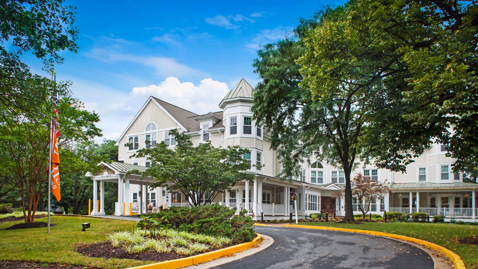 Sunrise of Arlington exterior building with driveway, trees, and landscaped grounds.