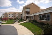 Exterior view of Londonderry Village brick buildings with curved walkway and lawn