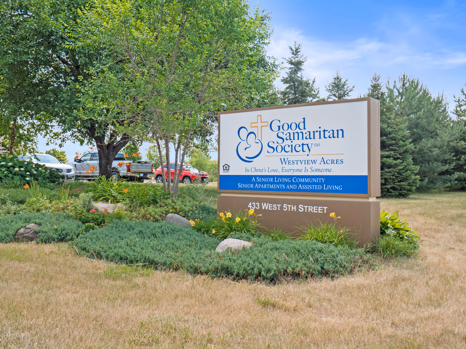 A large sign for Good Samaritan Society Westview Acres sits among landscaping on a grassy lawn.