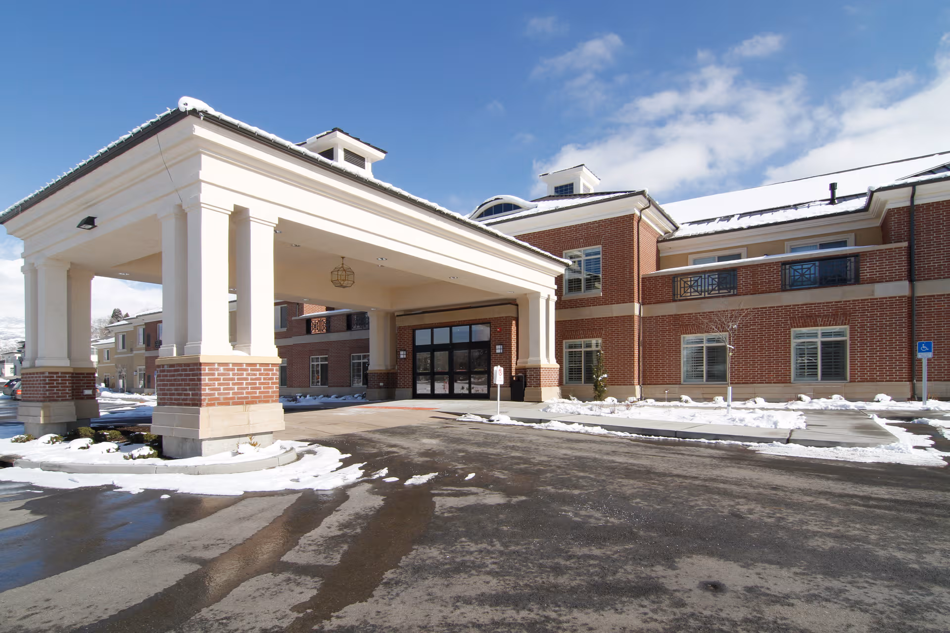 Front view of Legacy Village of Provo entrance with columns in snow