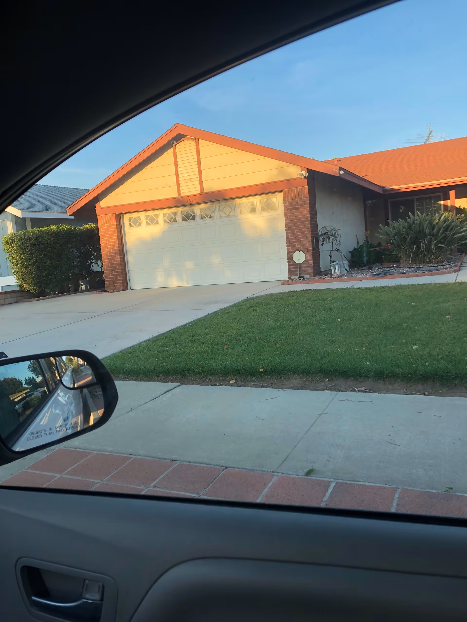 Front view of a two-car garage house with a green lawn and driveway.
