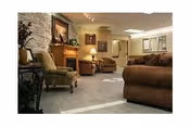 Cozy common living room in Legacy Rehab & Care Center with leather sofas and a fireplace.