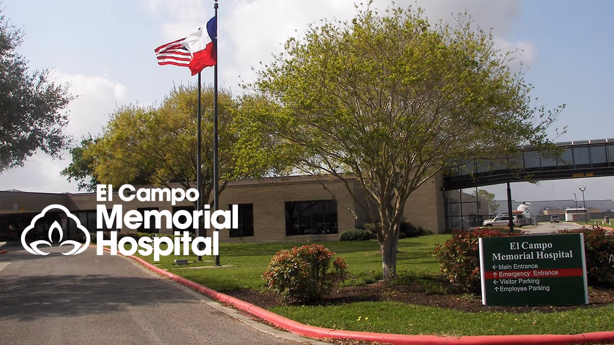 Exterior view of El Campo Memorial Hospital with flag and front sign.