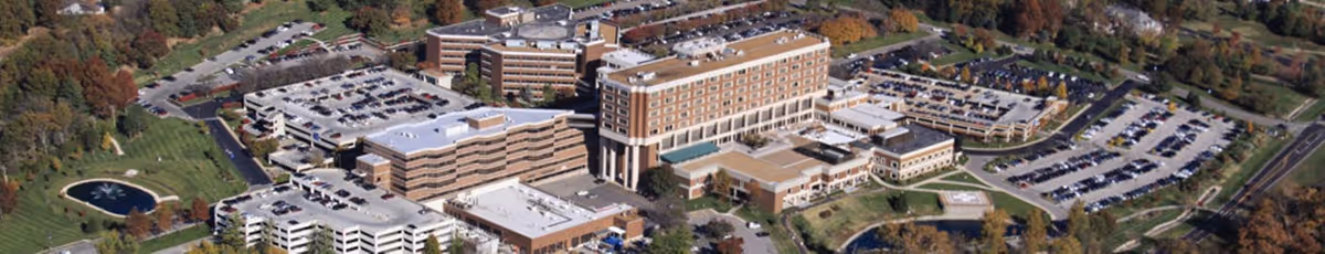 Aerial view of a large senior living campus with beige buildings and parking lots.