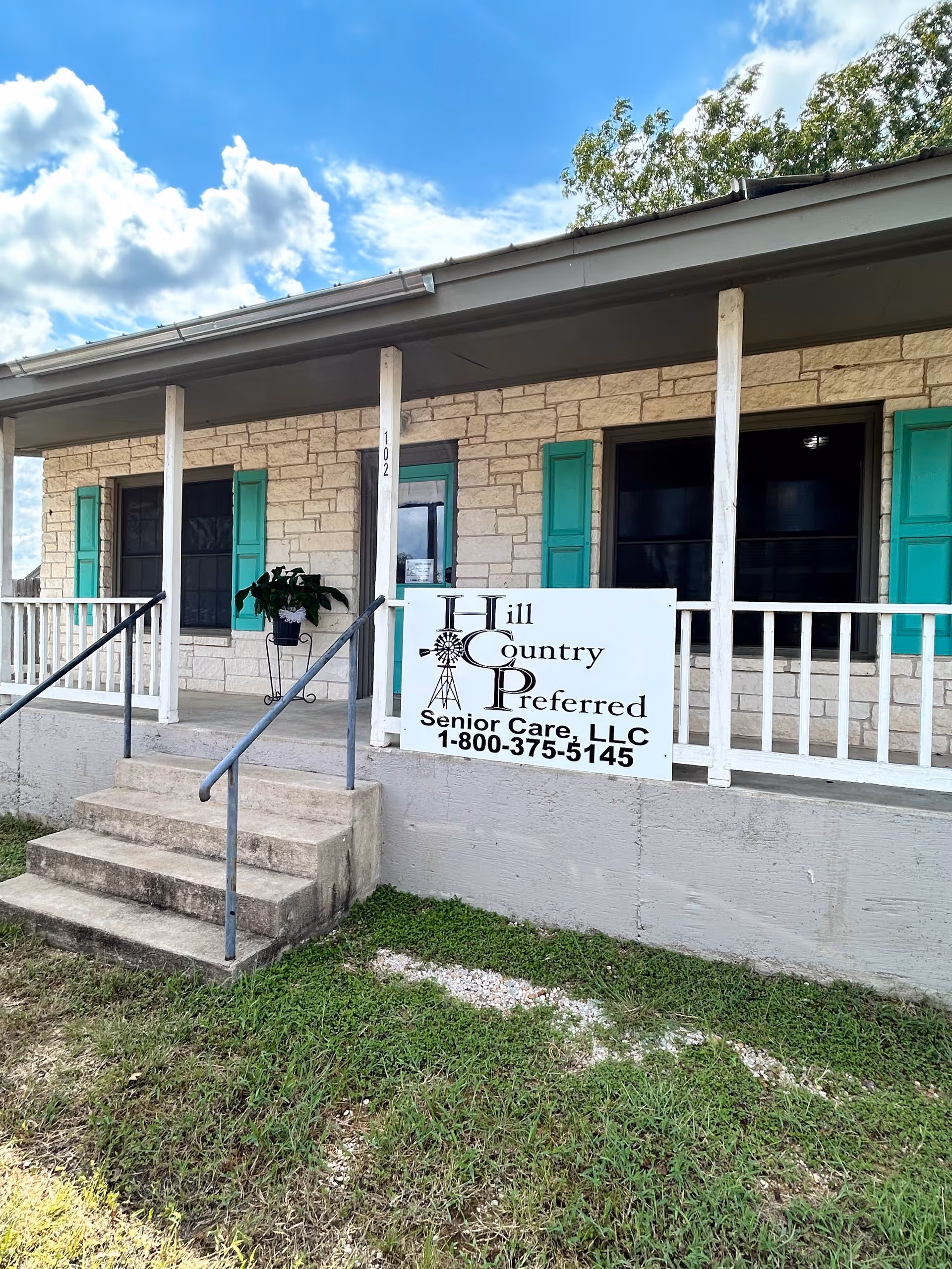 Front entrance of Hill Country Preferred Senior Care with turquoise shutters and sign.