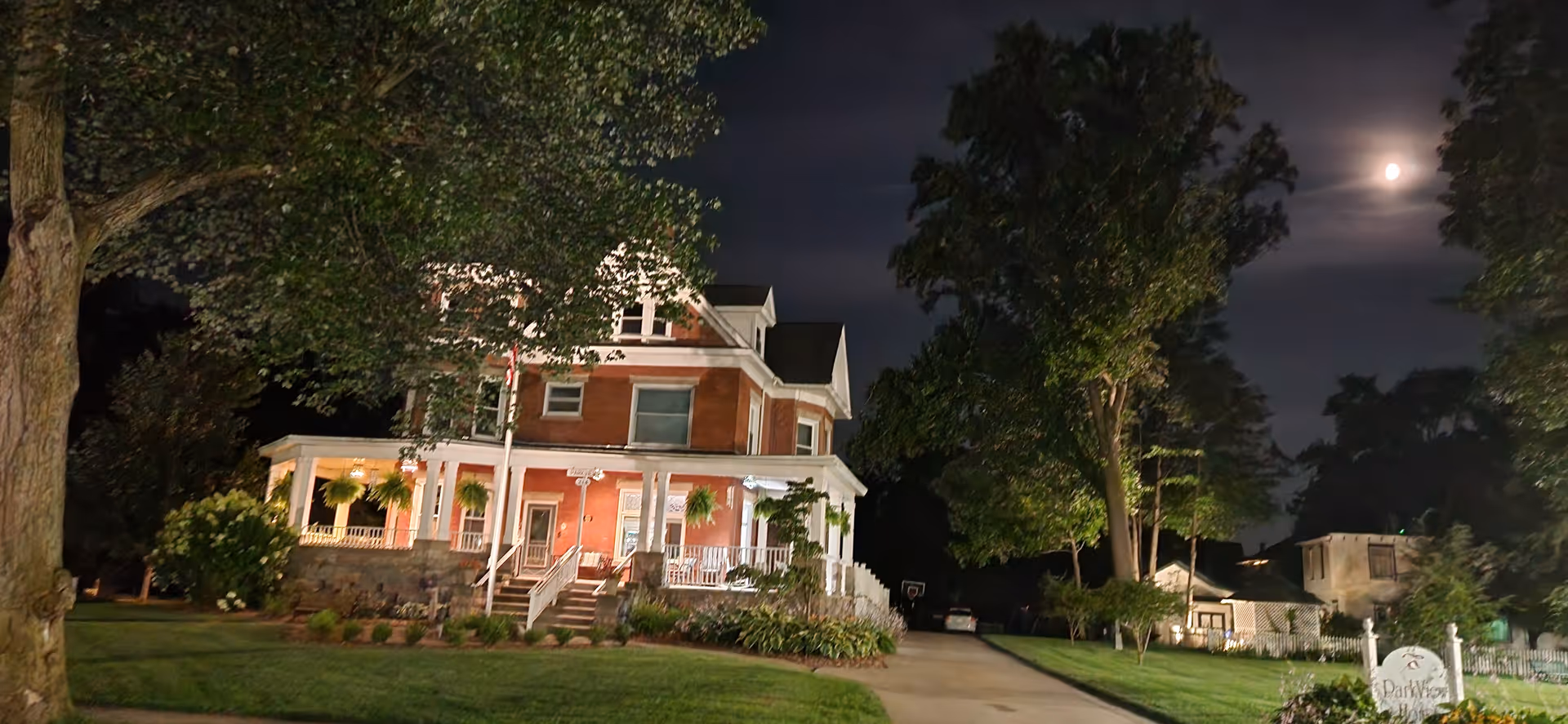 Nighttime exterior of Parkview Adult Foster Care Home with brick facade and lit porch.
