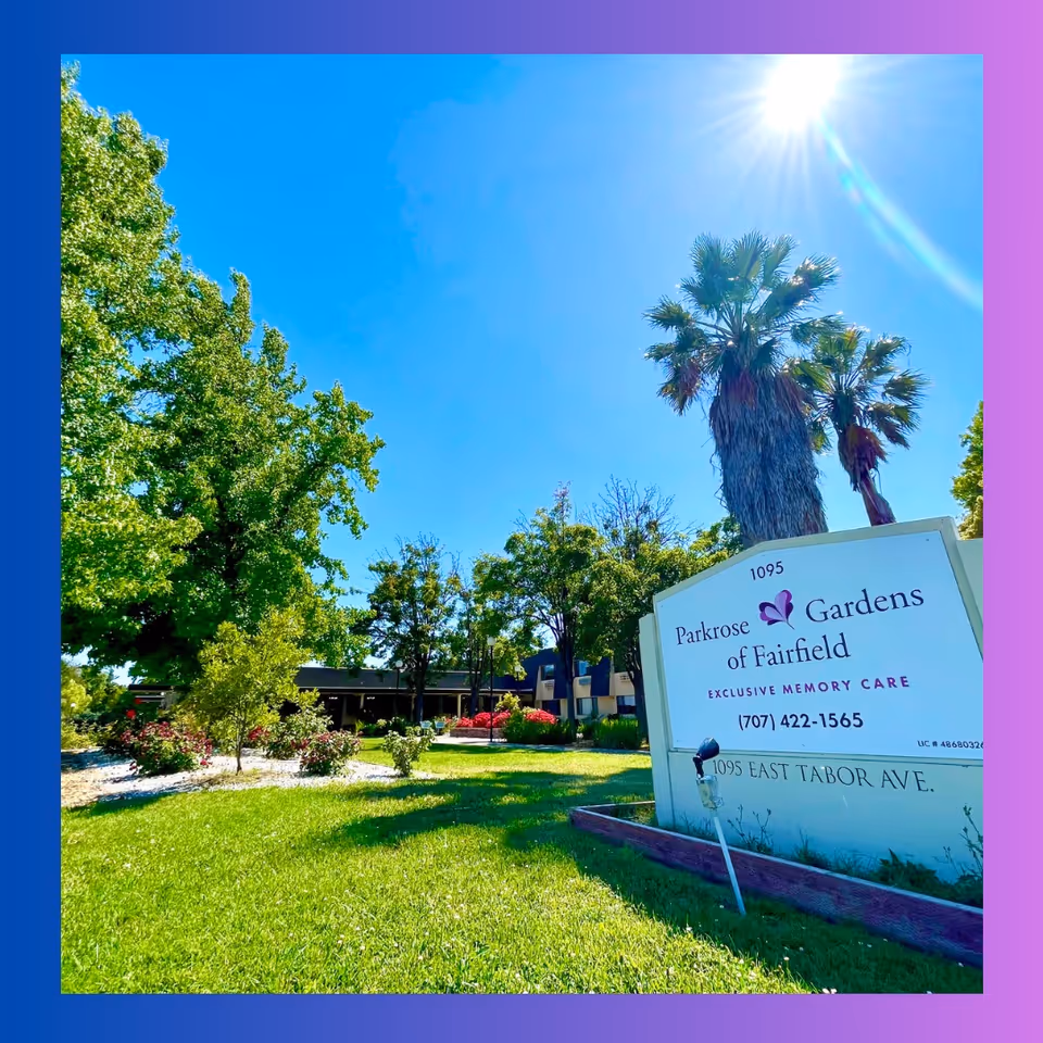 Sunny exterior view of Parkrose Gardens of Fairfield with sign and trees