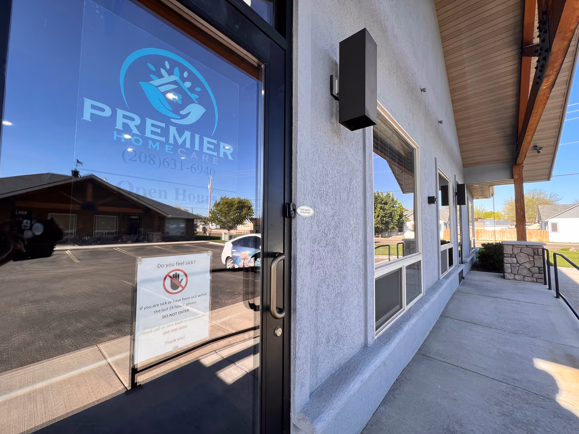 Exterior view of Premier Home Care facility entrance with glass door and signage.