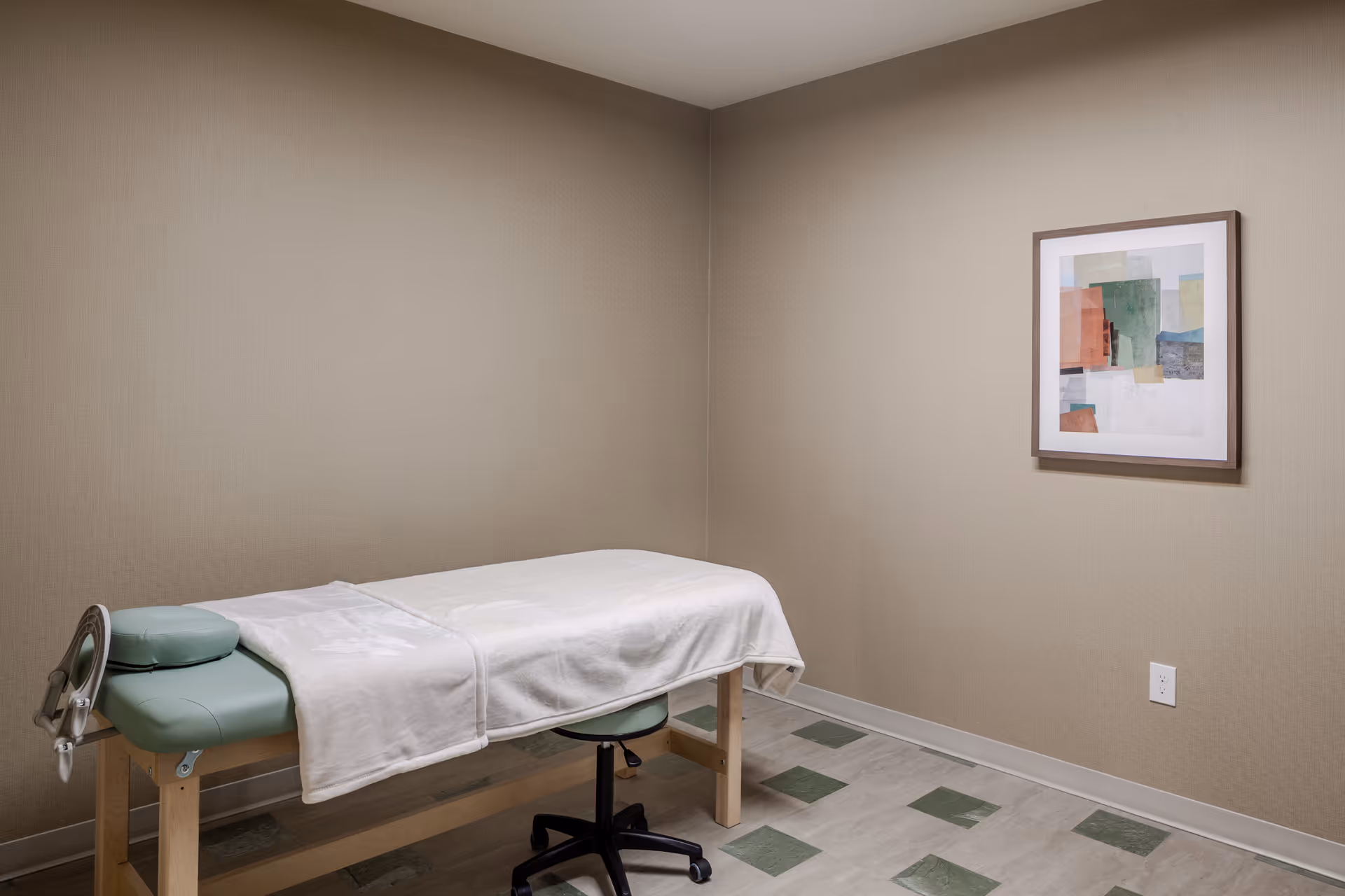 A therapy table in a neutral, beige room with abstract wall art.
