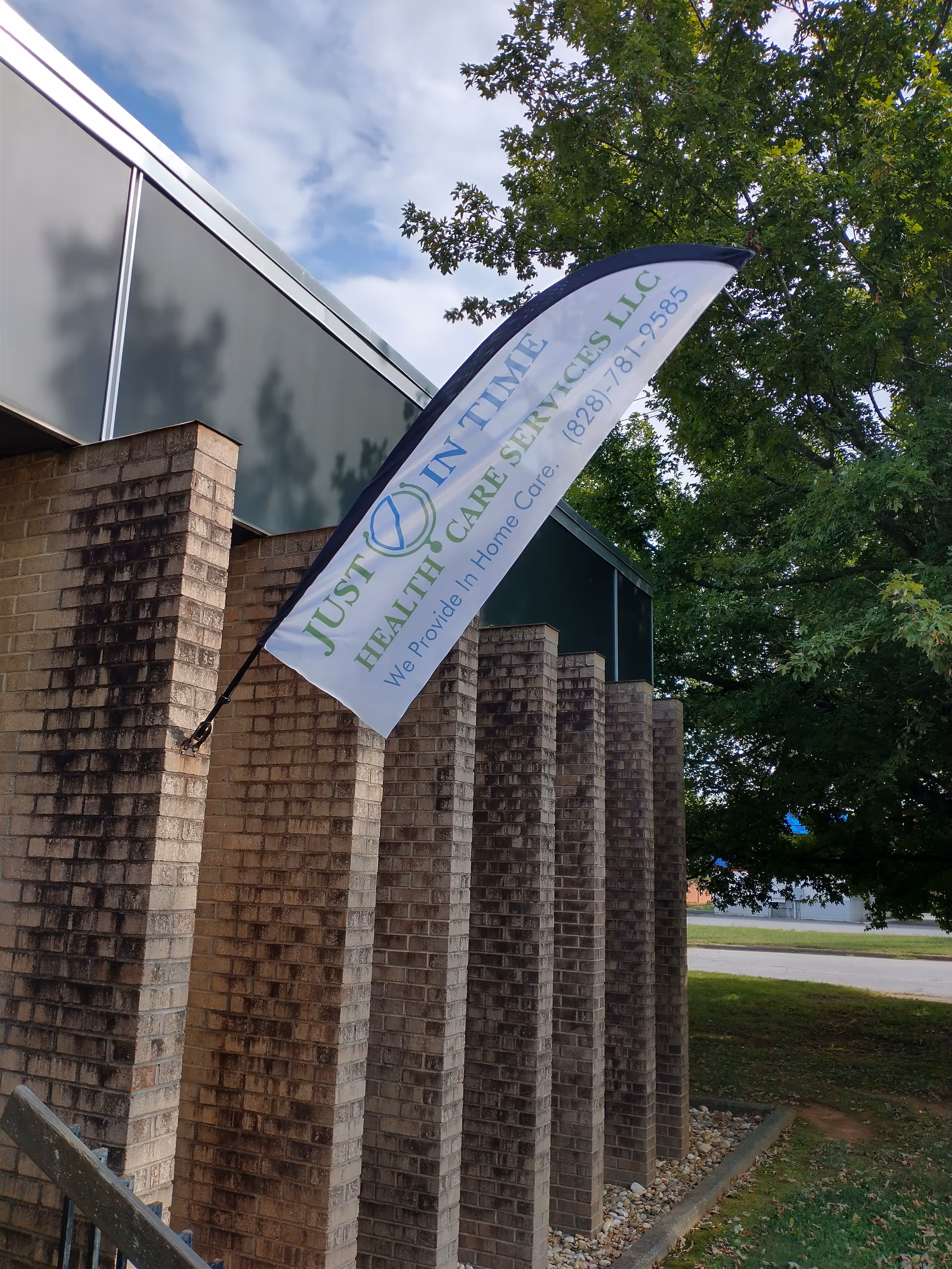 Exterior view of a brick building with a curved banner for Just in Time Health Care.