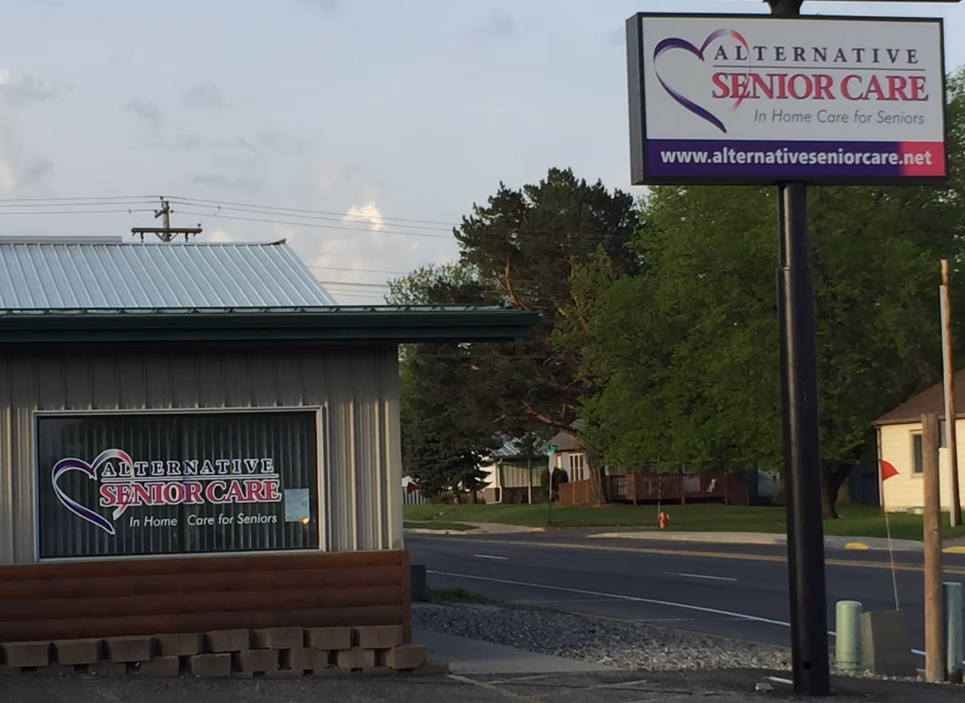 Exterior view of a metal-sided building with a sign reading Alternative Senior Care.