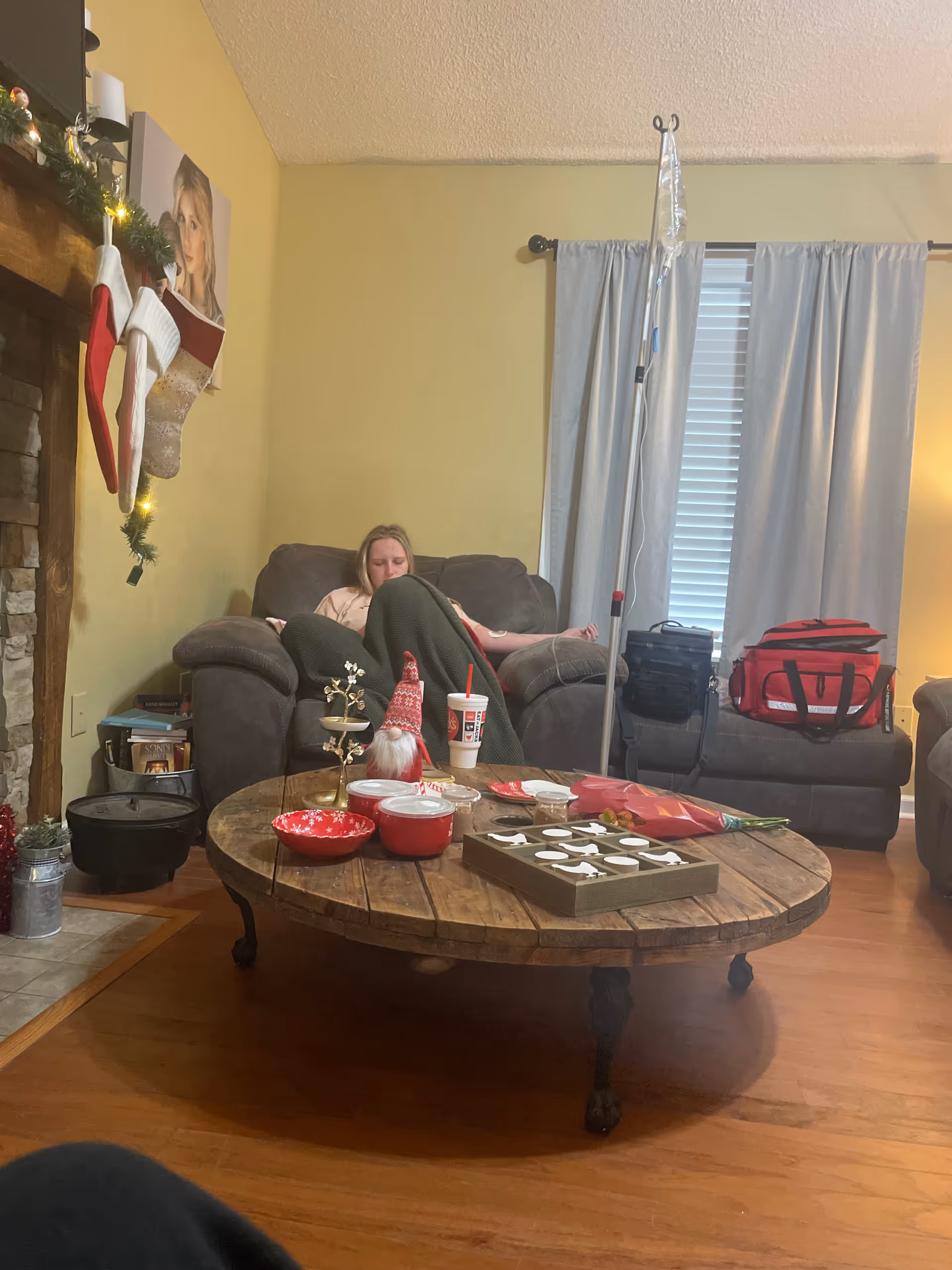 Resident relaxing on a couch in a cozy living room with Christmas stockings.
