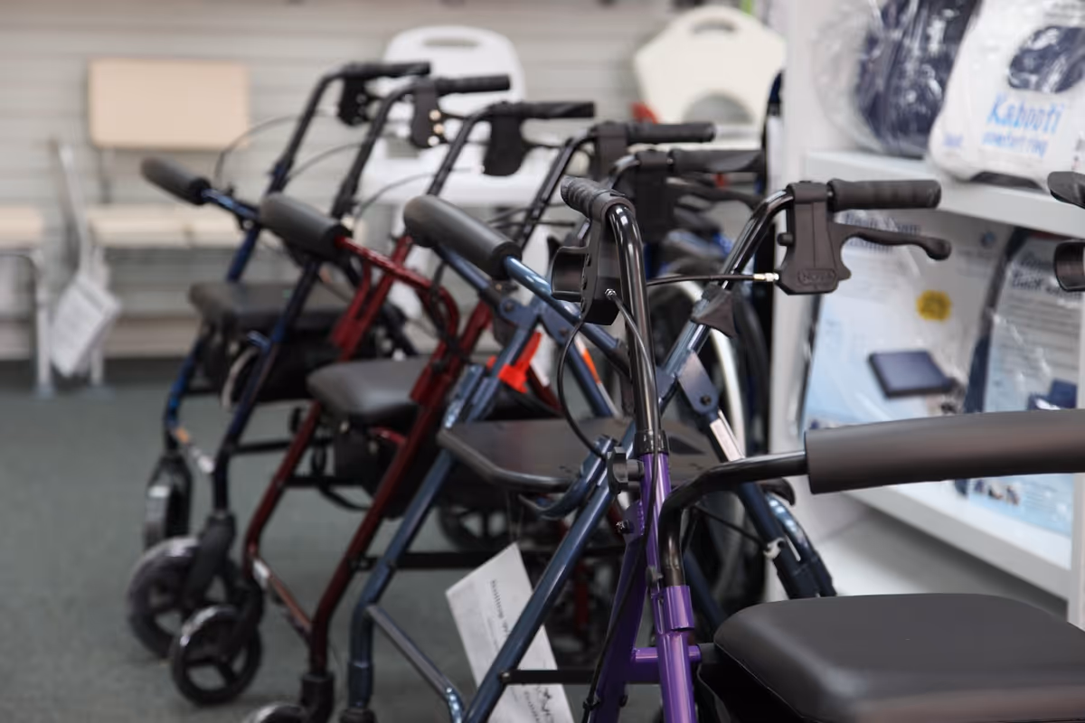 Indoor display of several walkers and mobility aids lined up in a showroom.