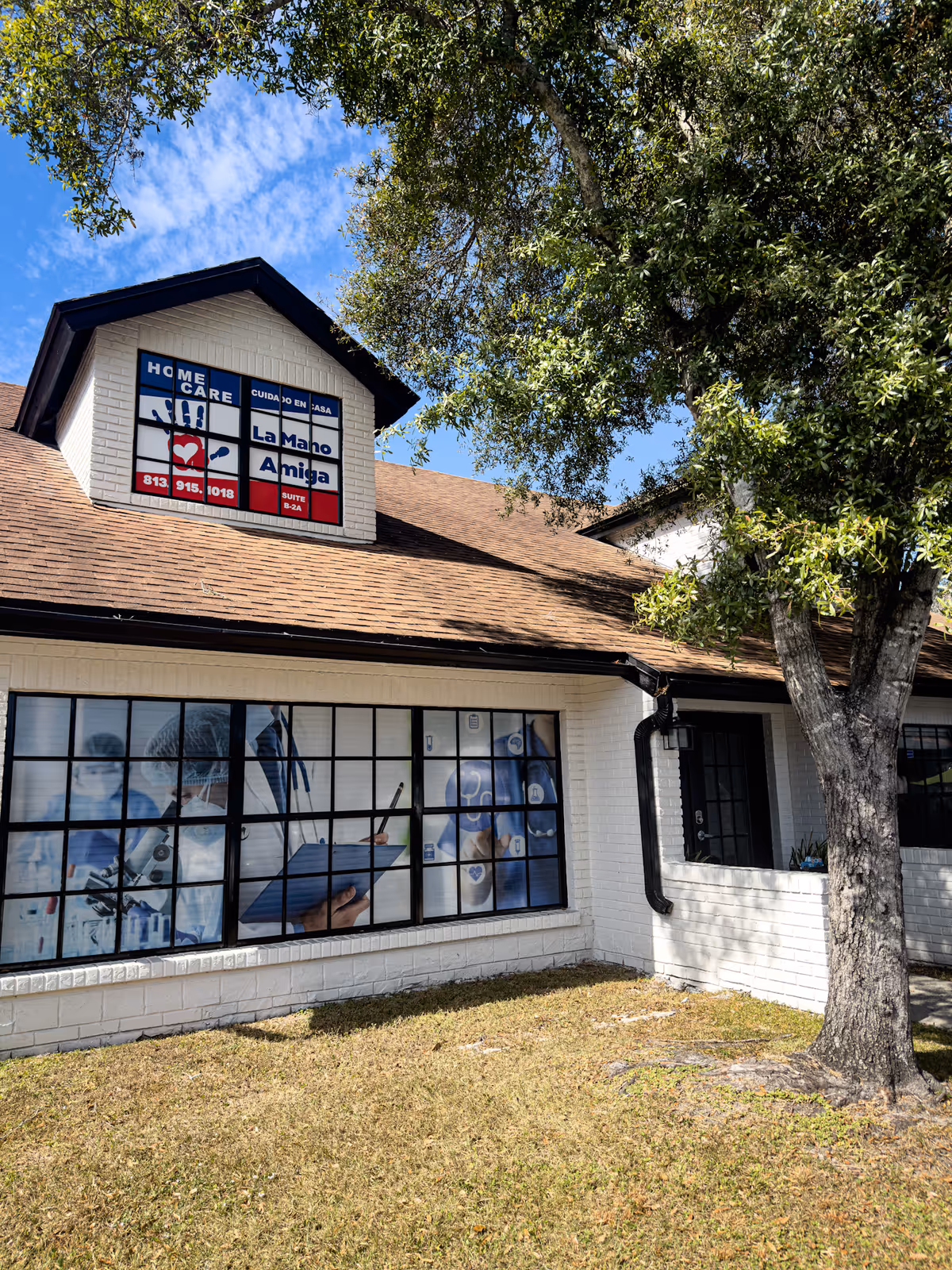 Exterior view of La Mano Amiga senior care building with signage and large windows.