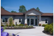 Front entrance of Allendale Nursing and Rehabilitation Community with glass doors and landscaped walkway.