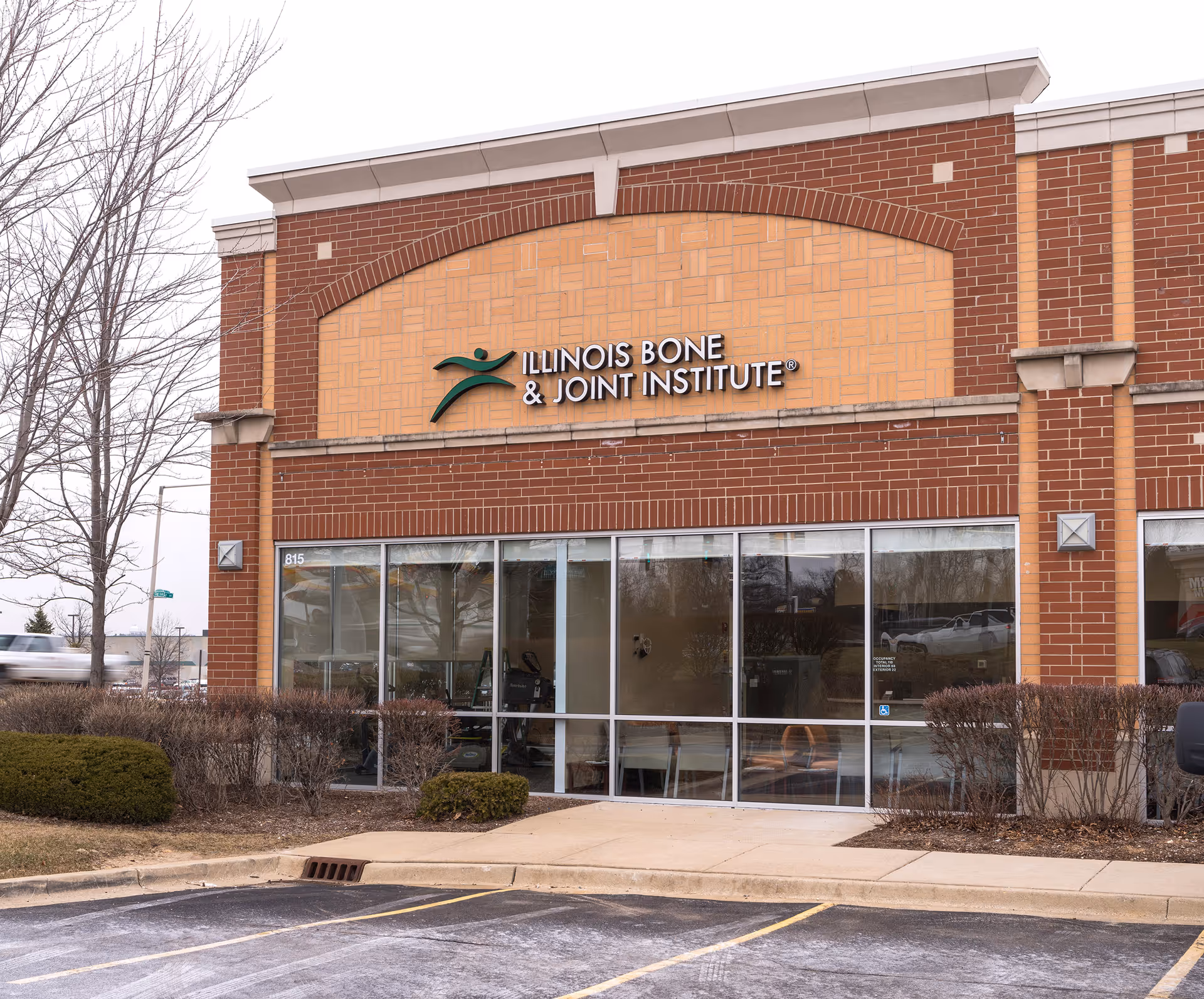 Brick storefront of Illinois Bone & Joint Institute with glass windows and signage.