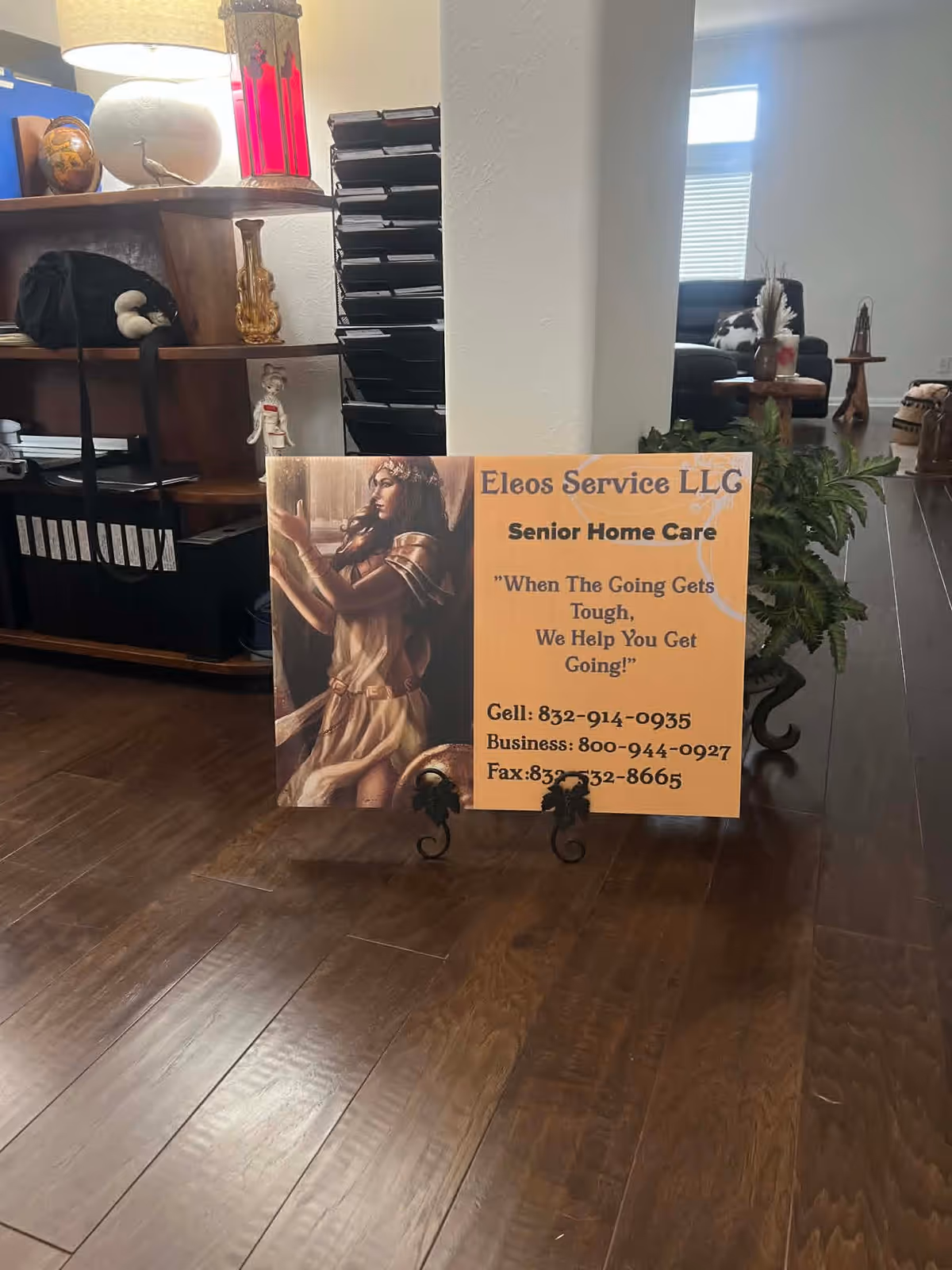 Orange Eleos Service LLC Senior Home Care sign in a wood-floored lobby.