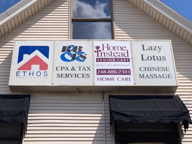 Front of a beige building with multiple business signs, including Home Instead Senior Care.