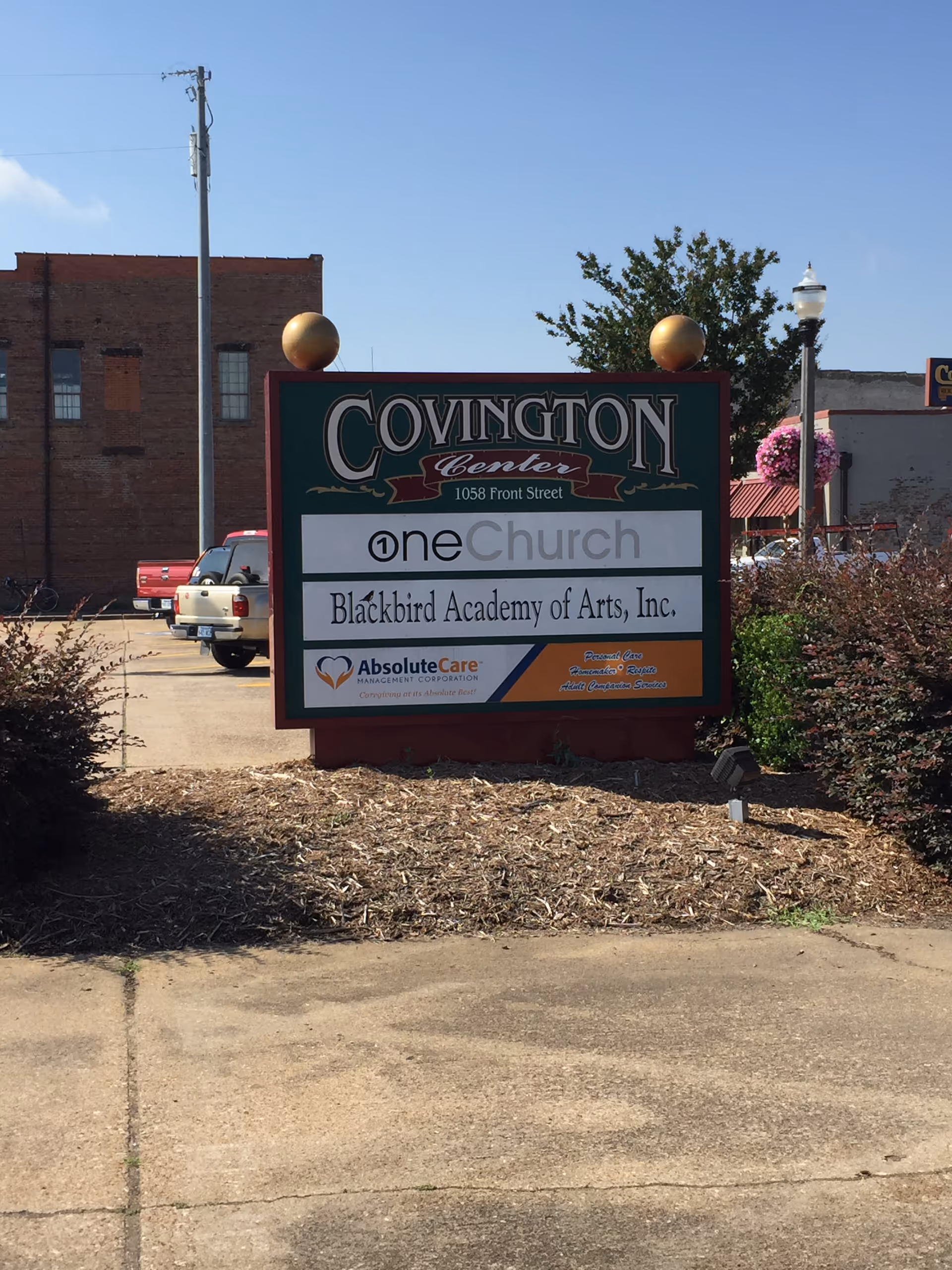 Outdoor sign in a mulched yard displays Covington Center and AbsoluteCare branding.