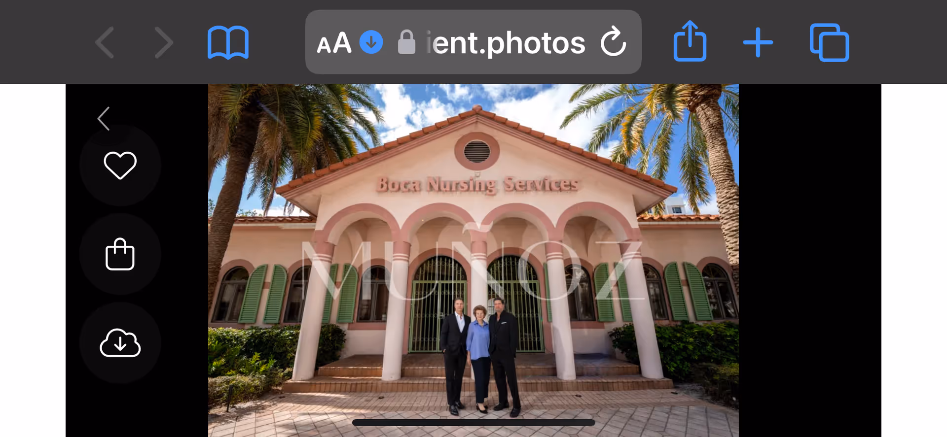 Pink Mediterranean-style building with arched entrance and three people standing in front.