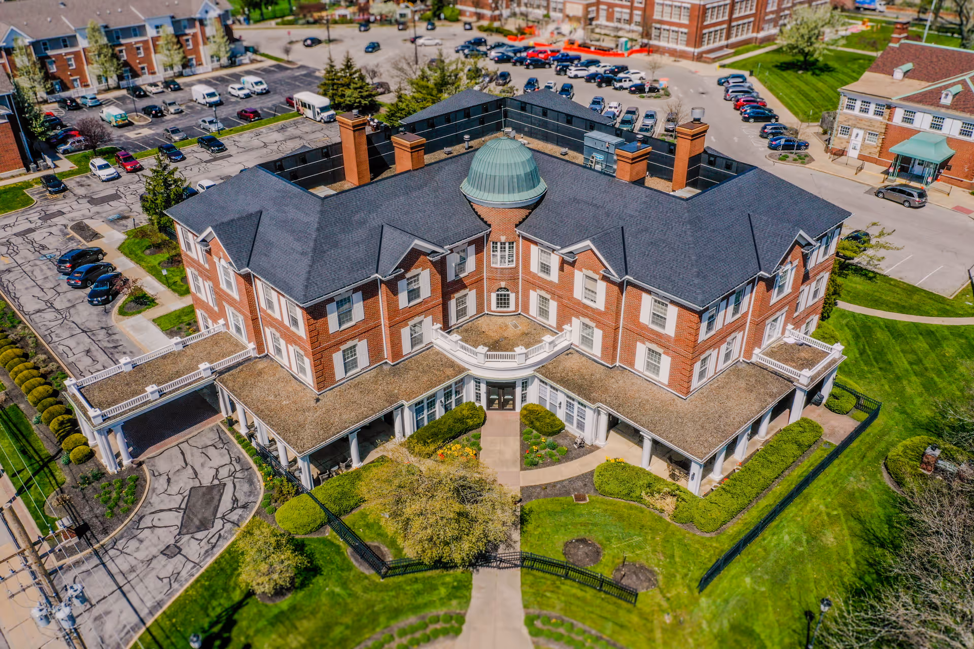 Aerial view of The Woodlands of Shaker Heights exterior building with parking and landscaped grounds.