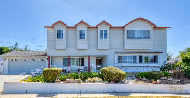 Exterior of Care Marstel 1 senior living facility, a two-story building with a manicured front yard.