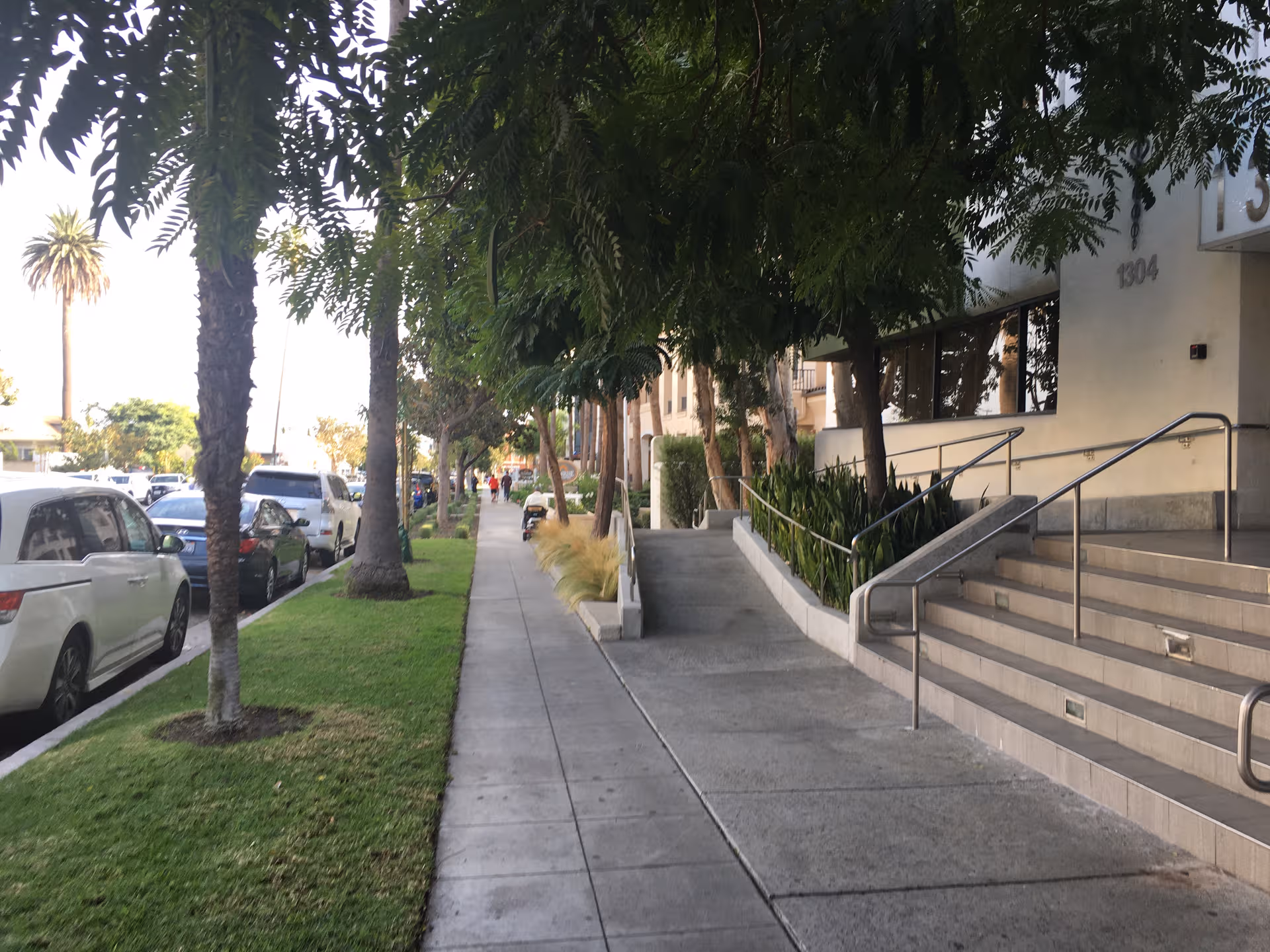 Exterior sidewalk view of Ivy Park at Santa Monica with stairs and trees.