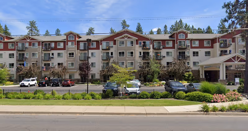 Exterior view of Affinity at Mill Road, a multi-story senior living building with parking.