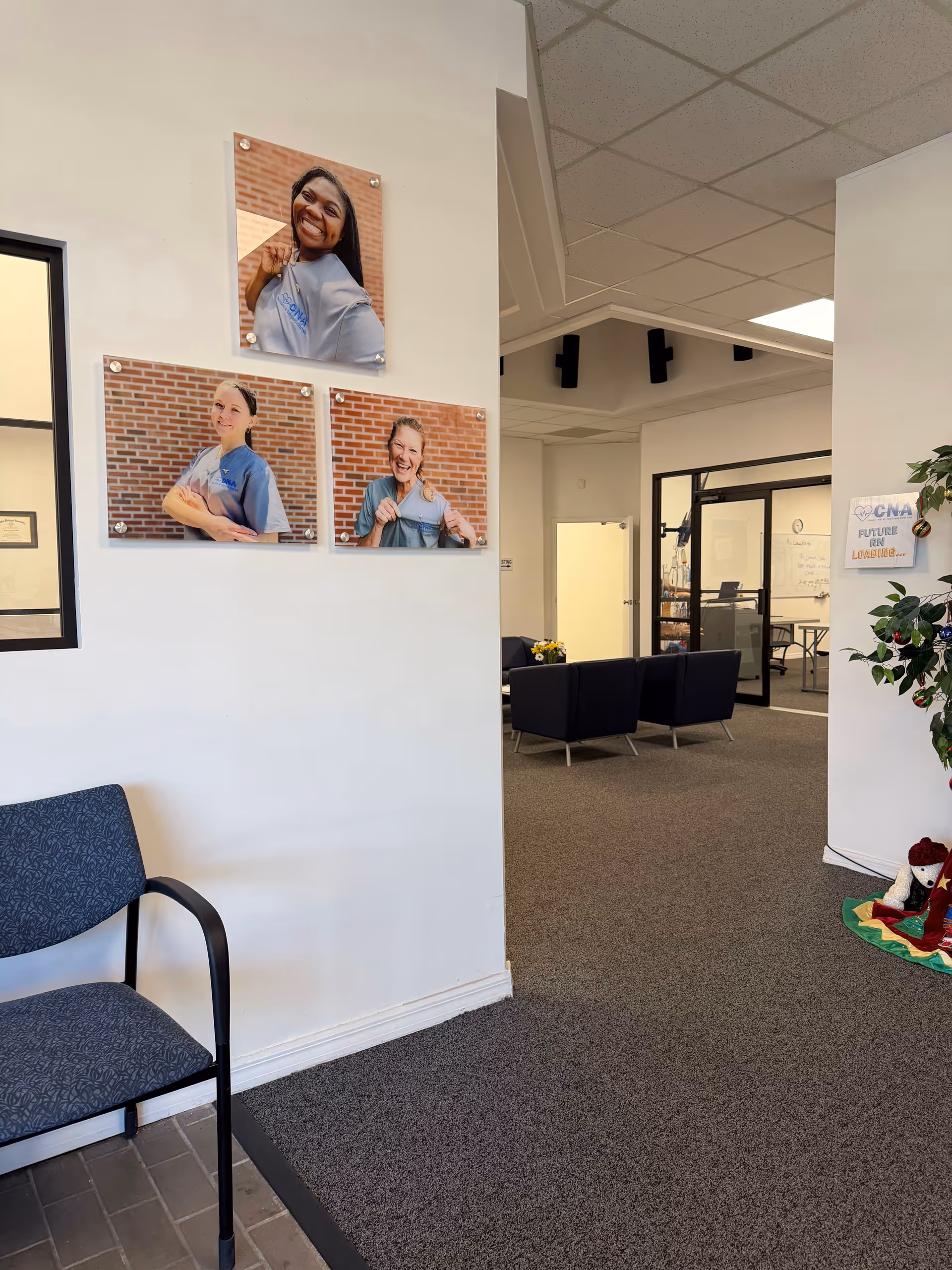 Interior reception area with blue chairs and wall posters of CNAs.