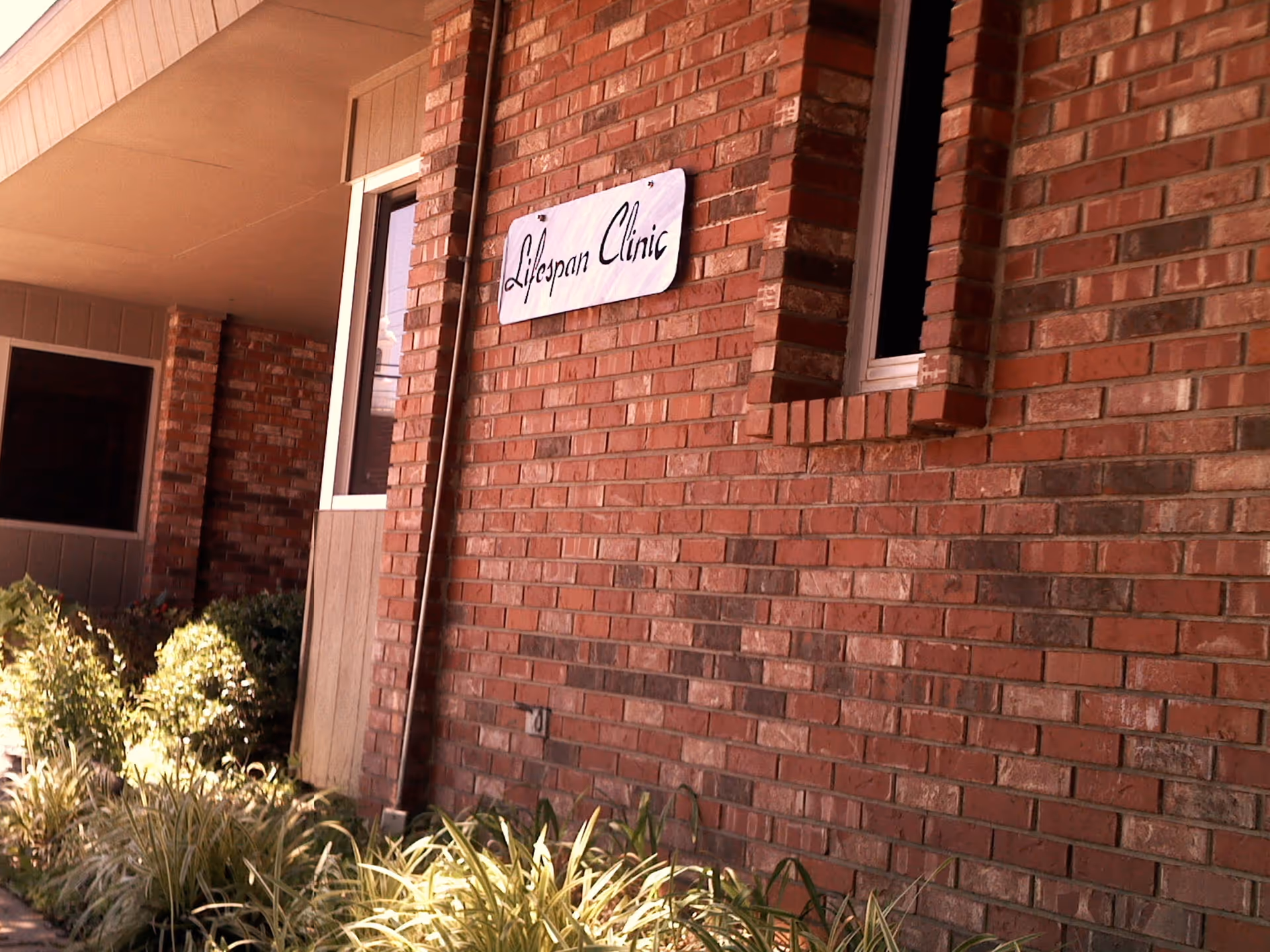 Brick exterior of Lifespan Clinic with a white sign mounted on the wall.