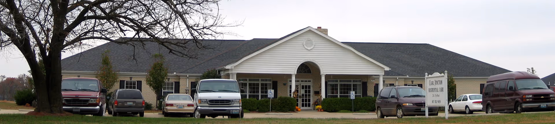 Front view of Carl Junction Residential Care Center with parked cars.
