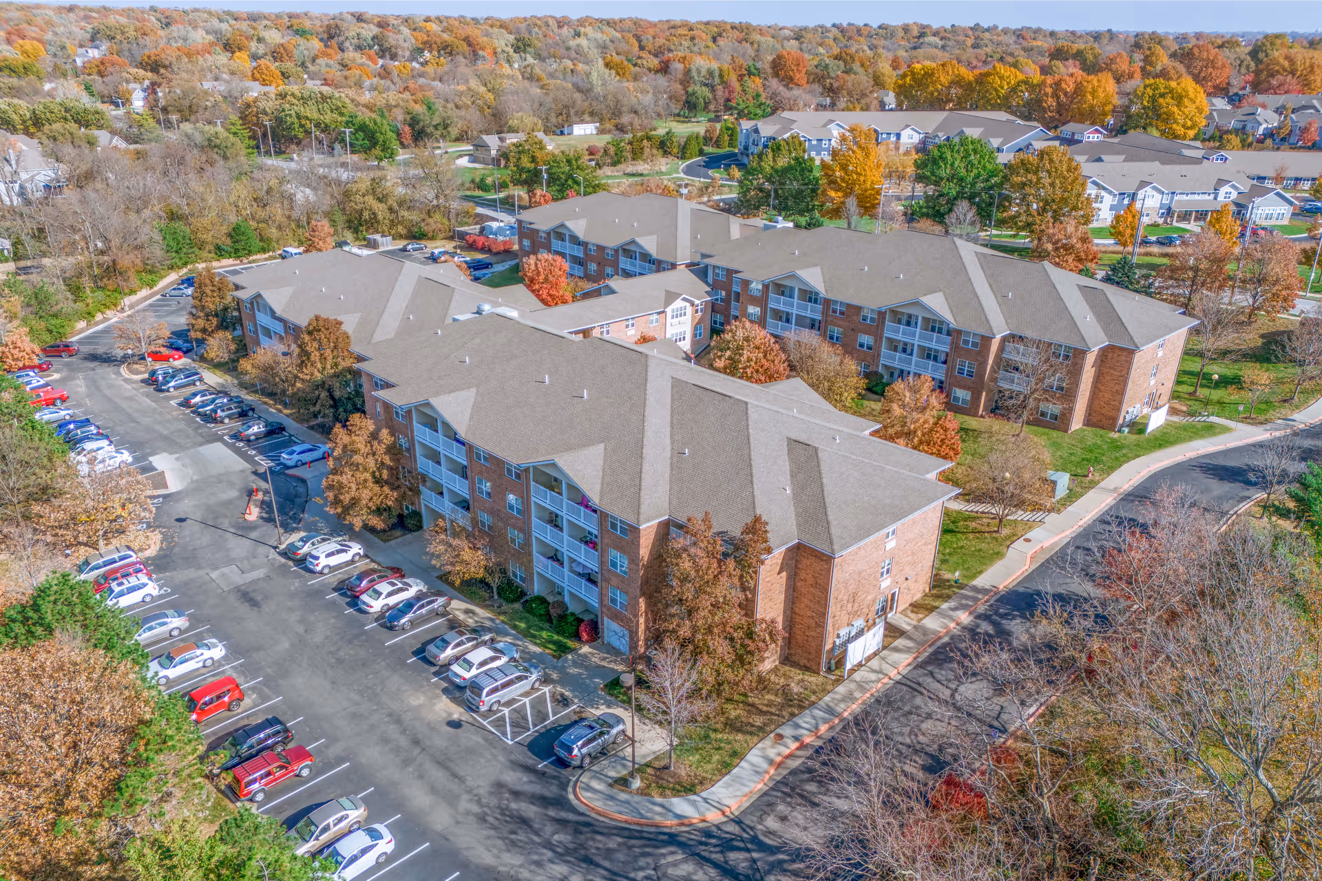 Aerial view of Rosewood Place senior living campus with brick buildings and parking lot.