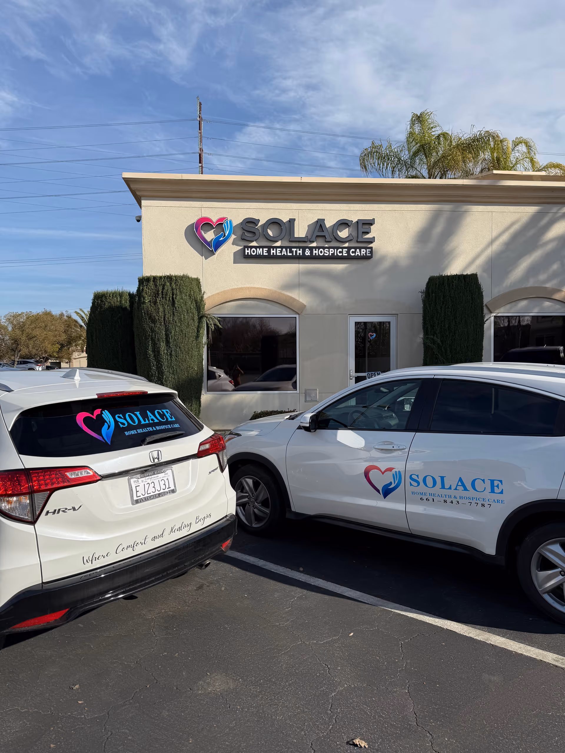 Front exterior of Solace Home Health & Hospice Care with branded cars.