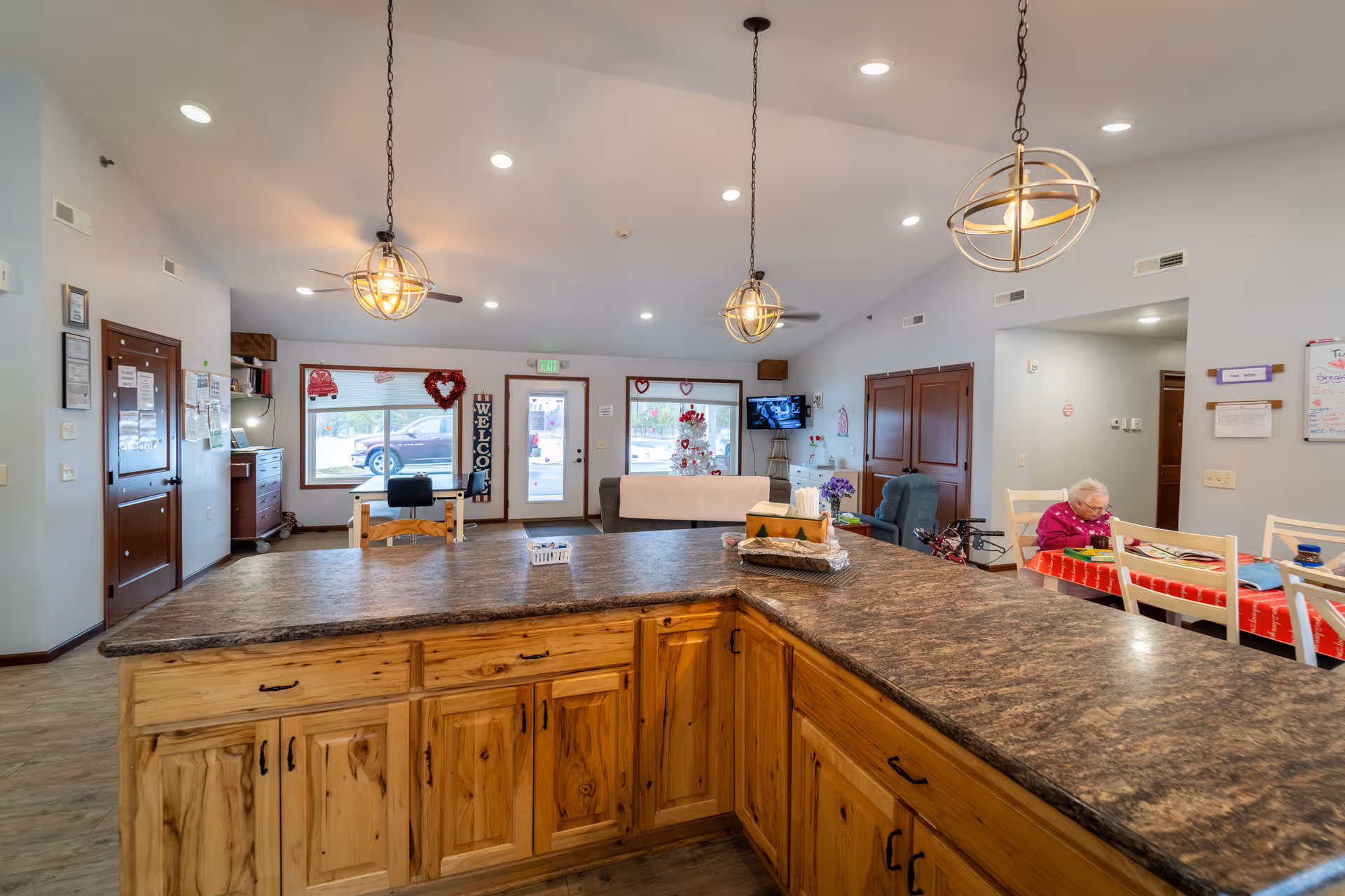 Open communal kitchen and dining area with a large wood island and seating.