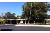 Front exterior of Windsor El Camino Care Center with driveway and palm trees