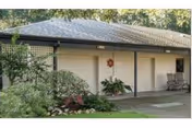A single-story Sunnyside Village facility exterior with three garage-style bays and landscaping.