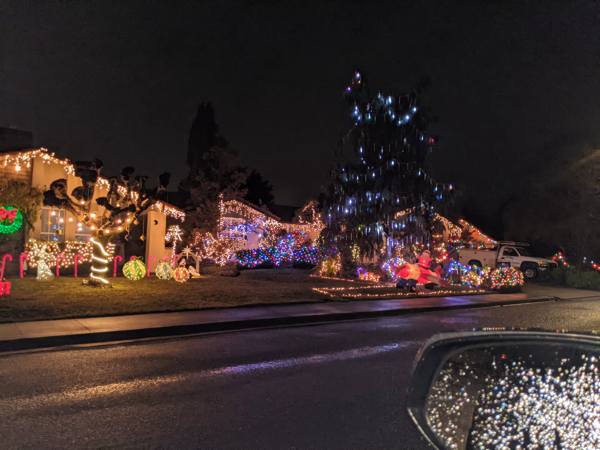 Exterior of Springfield Place senior facility lit with festive colorful holiday lights at night.