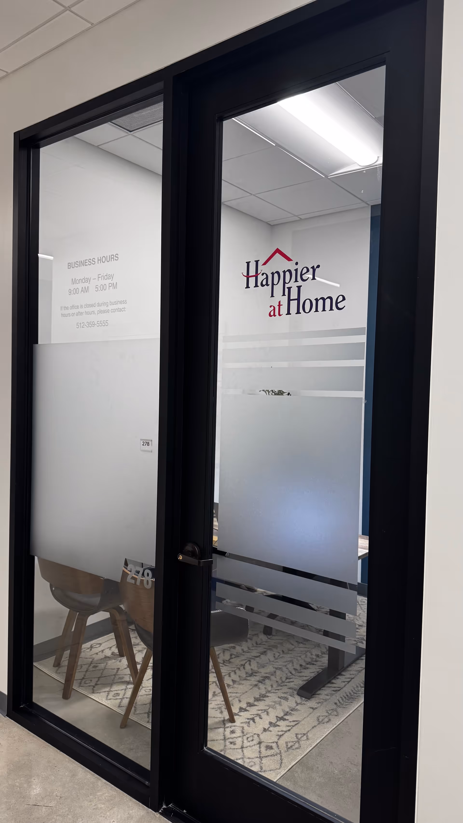 Interior office doorway featuring the Happier at Home logo and frosted glass stripes.