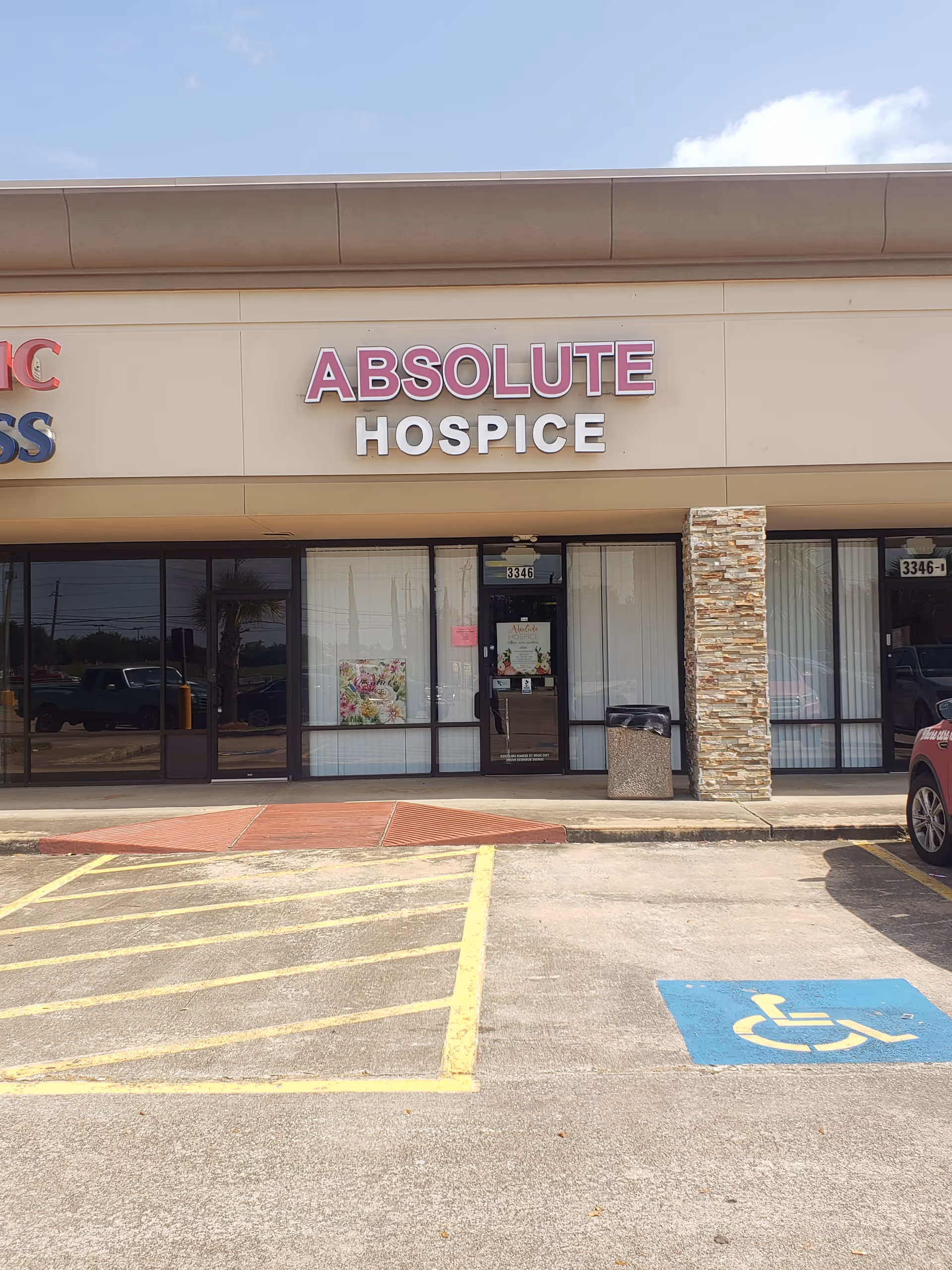 Front view of Absolute Hospice storefront with glass doors and parking lot.