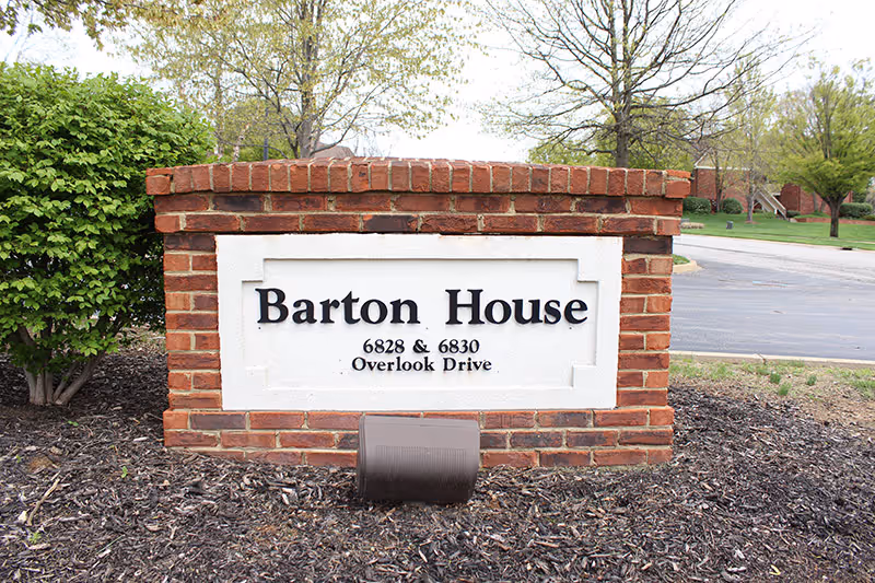 Brick Barton House sign on a landscaped front lawn near Overlook Drive.