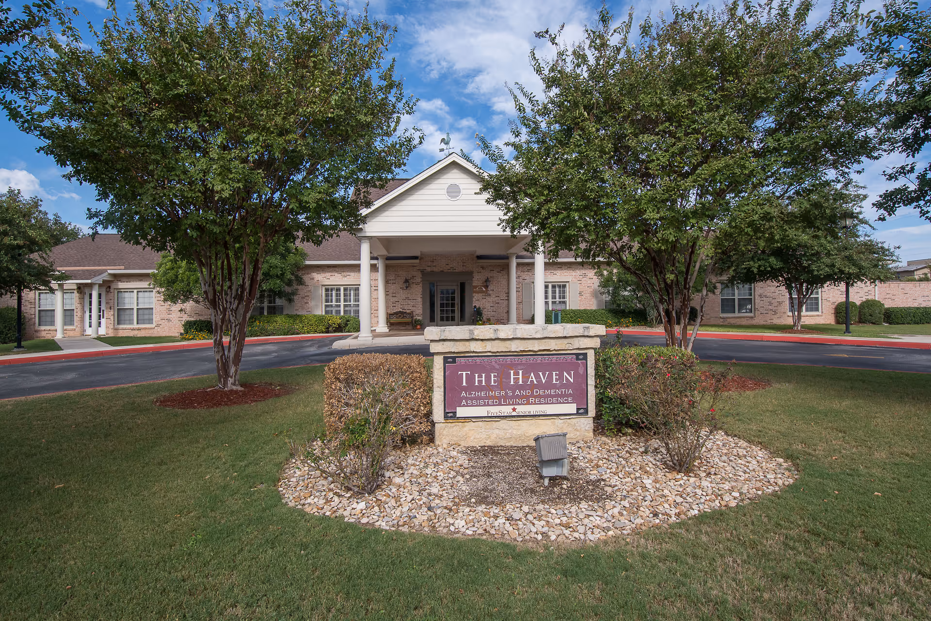 Front view of The Haven building with entrance, stone sign, and landscaped approach.