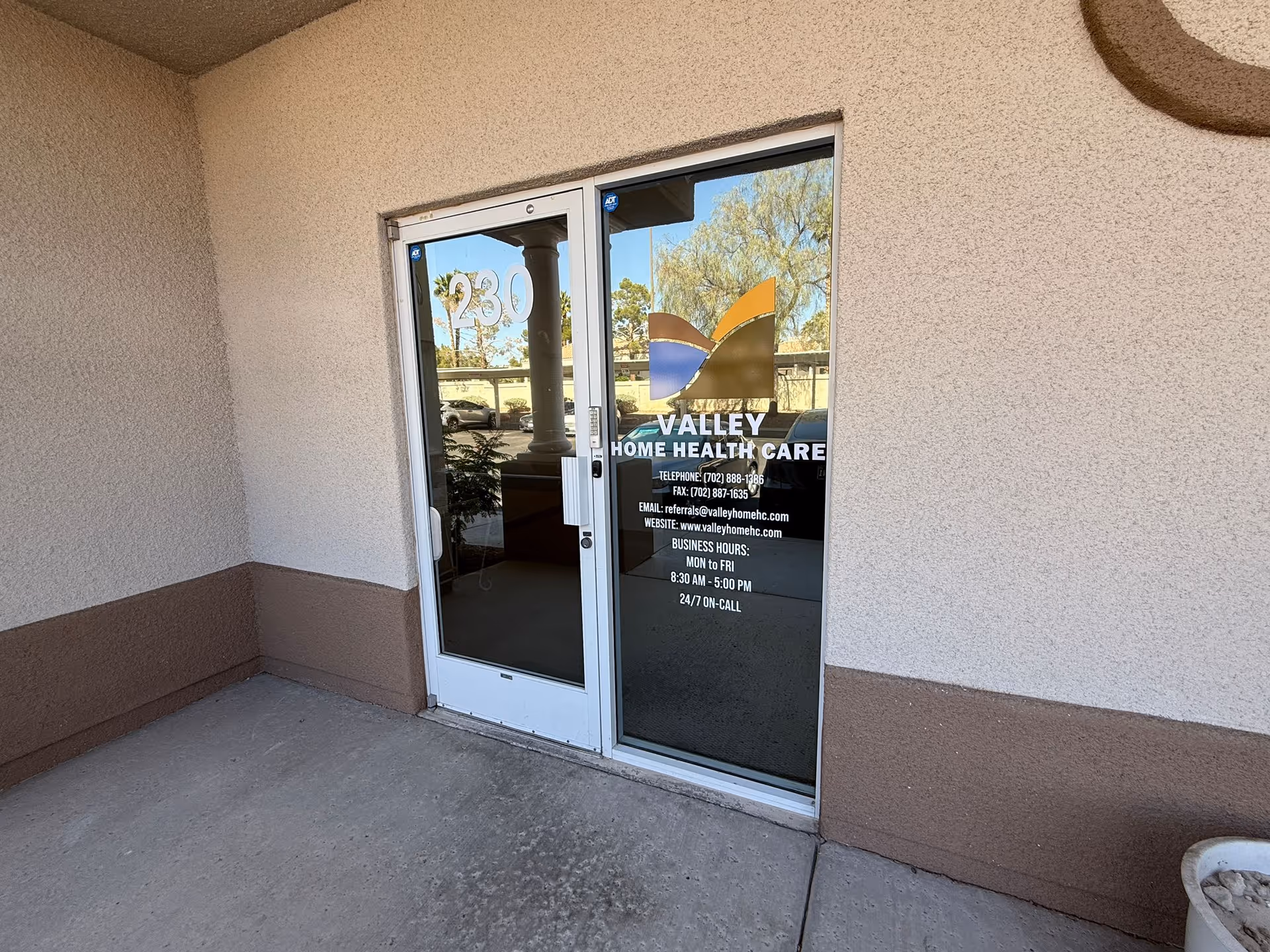 Entrance glass doors with Valley Home Health Care signage on beige exterior wall.