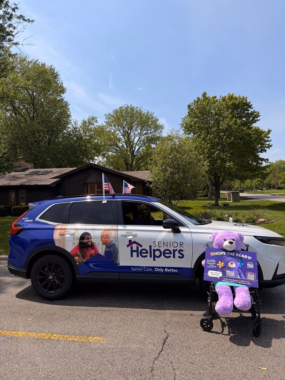 Senior Helpers branded van parked outdoors; purple bear on a cart.