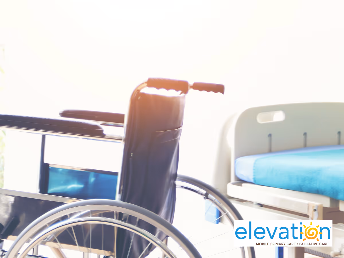 Wheelchair beside a hospital bed in a bright patient room.