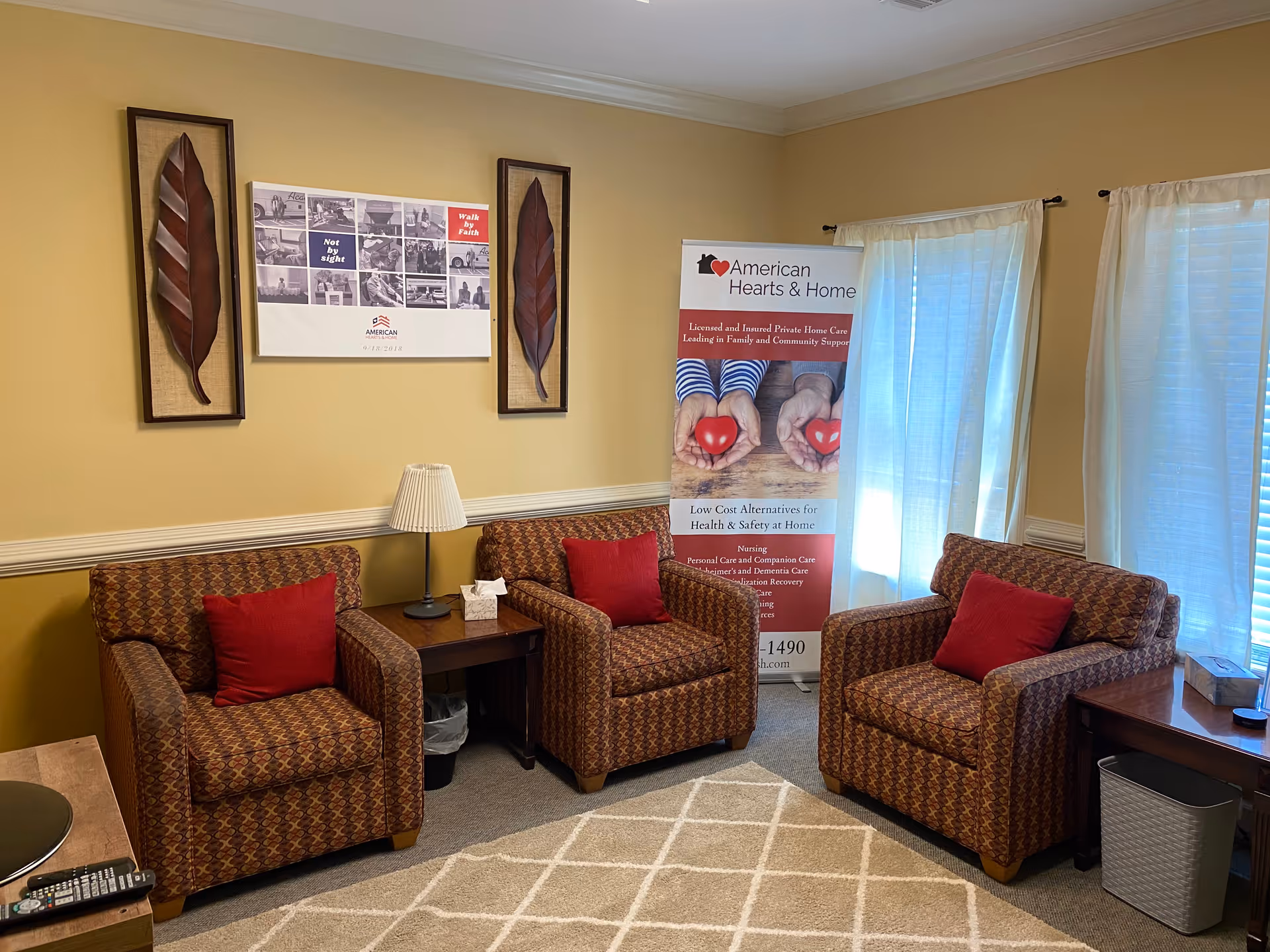 Cozy lounge with three patterned armchairs around a side table and a promotional banner