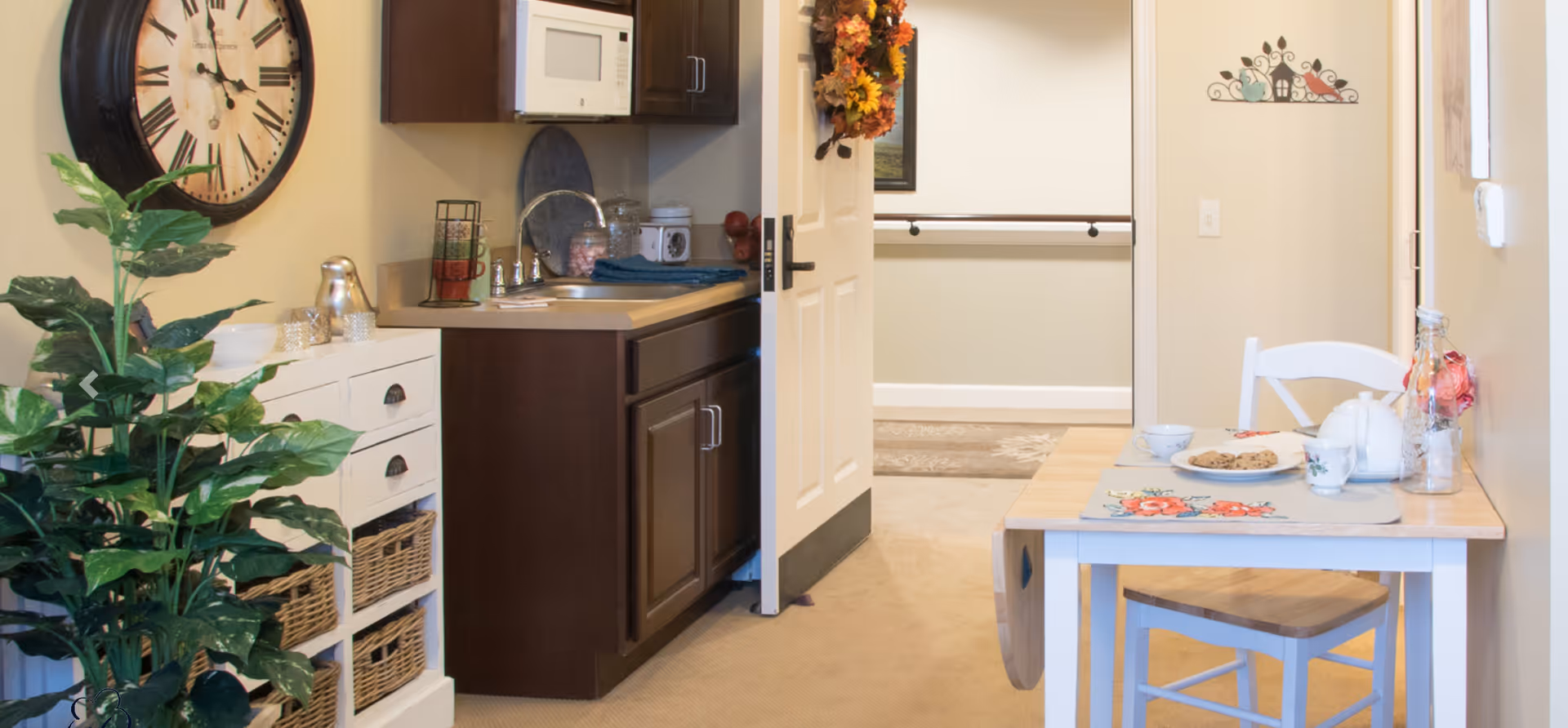 Compact kitchen and dining area with sink, cabinets, and a table set for cookies.