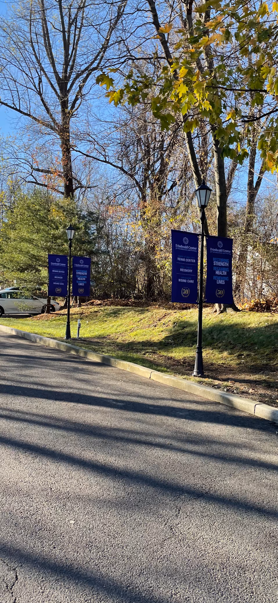 Blue banners along lampposts line a road in front of Friedwald Center for Rehab and Nursing.