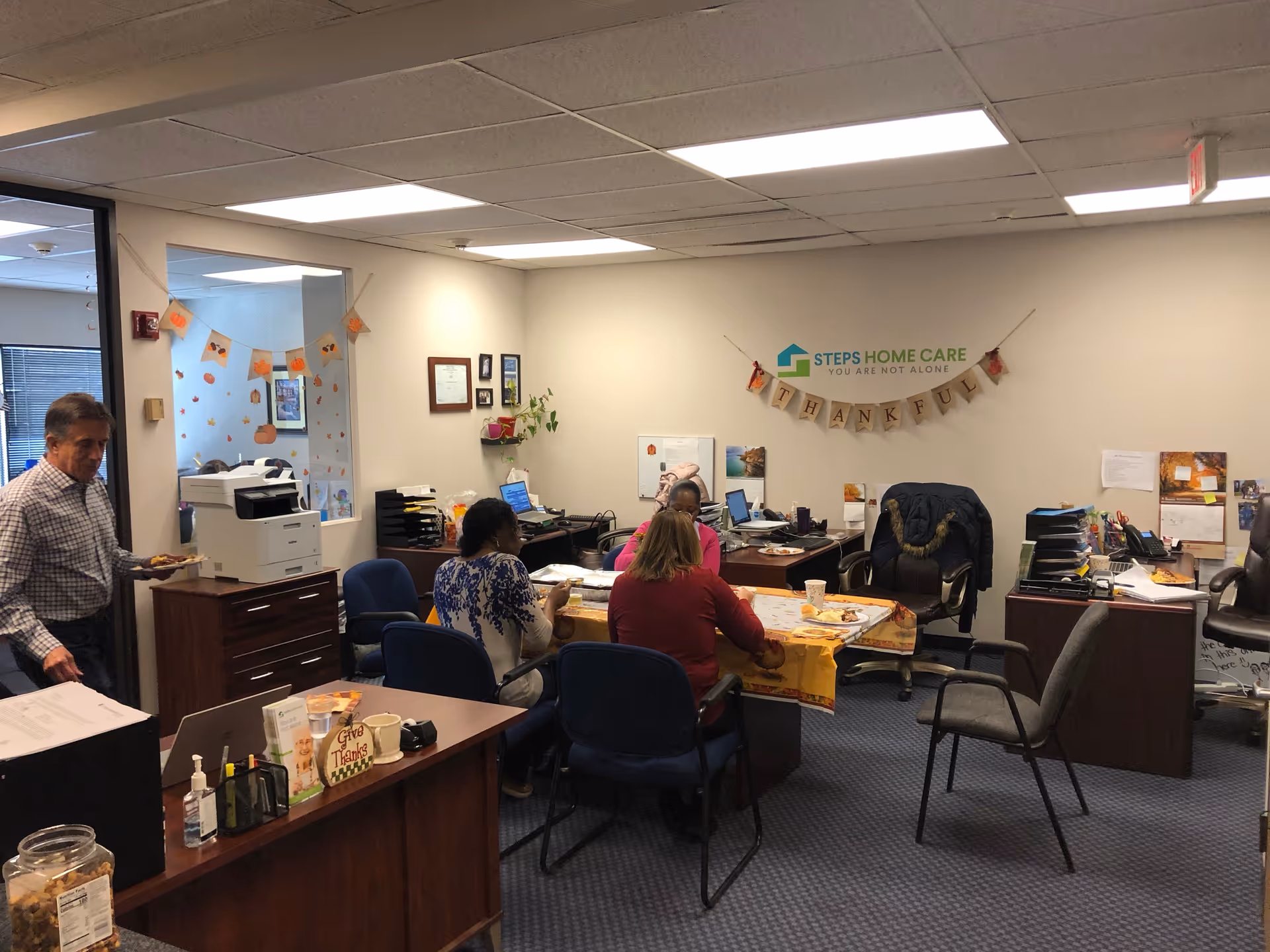 Office workspace at STEPS Home Care with staff seated around a table and computers.